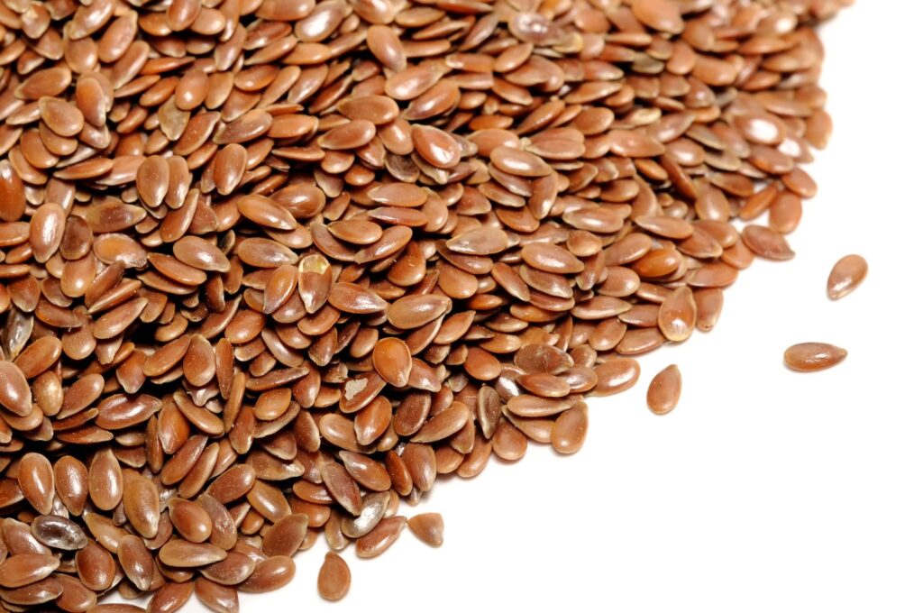 15359408 - brown flax seeds on white background